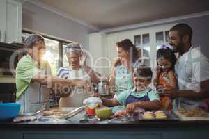 Happy family preparing dessert in kitchen