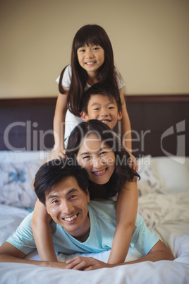 Happy family having fun on bed in the bed room