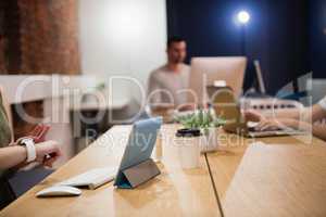 Female executive adjusting smart watch at desk