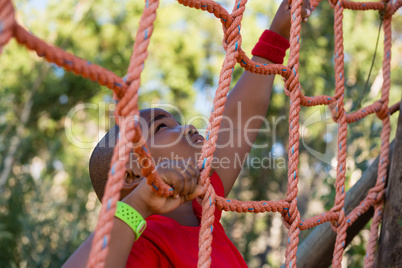 Boy climbing a net during obstacle course training