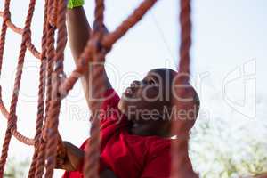 Boy climbing a net during obstacle course training