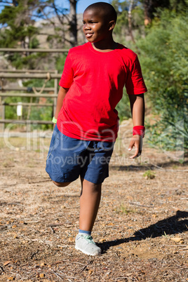 Boy performing stretching exercise during obstacle course training