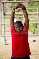 Boy performing stretching exercise during obstacle course training