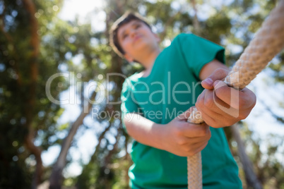 Boy practicing tug of war during obstacle course training