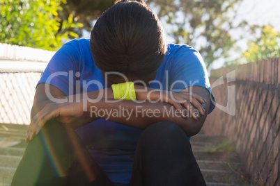 Upset woman sitting on staircase in the boot camp