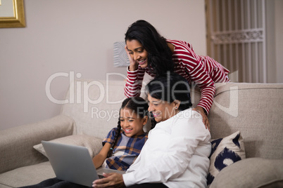 Happy multi-generation family using laptop together