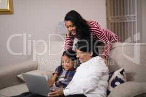 Happy multi-generation family using laptop together