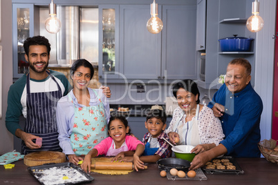 Portrait of multi-generation family smiling together while preparing food
