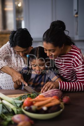 Smiling multi-generation family preparing food in kitchen