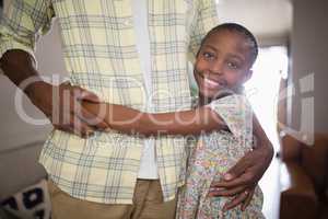 Smiling girl embracing father at home