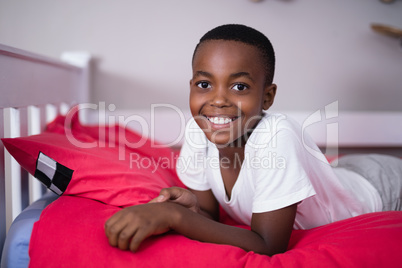 Portrait of smiling boy lying on bed