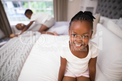 Portrait cheerful girl sitting on bed