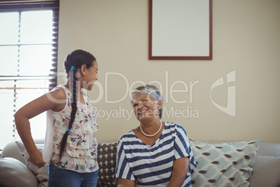 Grandmother interacting with granddaughter in living room