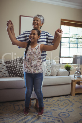 Grandmother and granddaughter having fun in living room