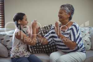 Grandmother and granddaughter having fun in living room