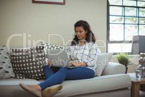 Woman using laptop in living room