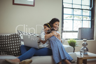 Mother hugging daughter in living room