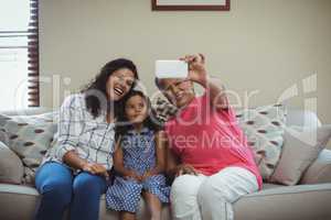 Happy family taking a selfie on mobile phone in living room