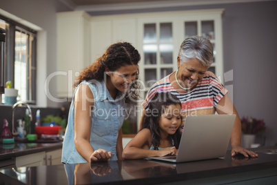 Happy family using laptop in kitchen