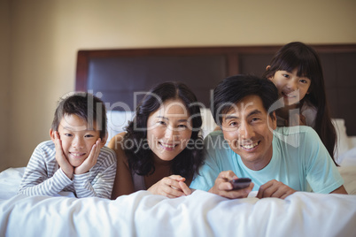 Happy family watching television in the bed room