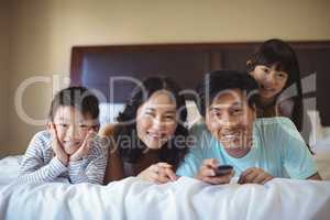 Happy family watching television in the bed room