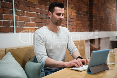 Male executive using digital tablet at desk