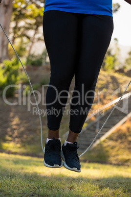Low-section of woman skipping rope in the park
