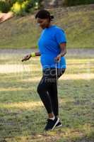 Fit woman skipping rope in the park