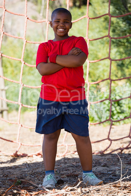 Boy standing with arms crossed during obstacle course training