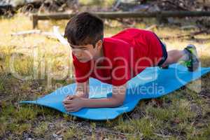 Boy exercising on exercise mat during obstacle course training