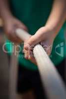 Boy practicing tug of war during obstacle course training in the boot camp