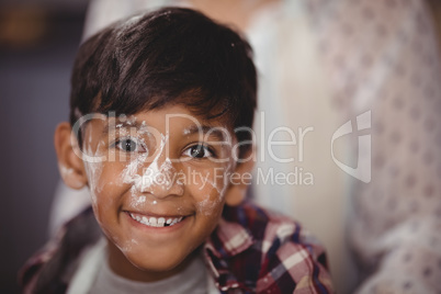 Portrait of smiling boy with flour on face