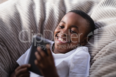 Little boy playing with phone on couch
