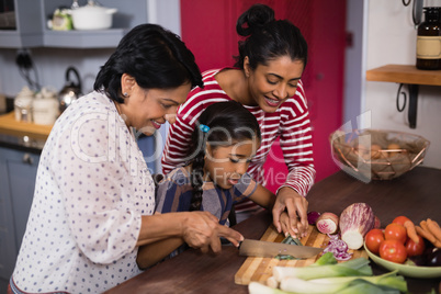 Multi-generation family preparing food together in kitchen