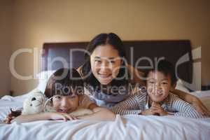 Mother with daughter and son relaxing on bed in bed room