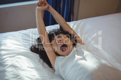 Girl yawning on bed in the bed room