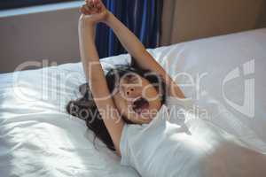 Girl yawning on bed in the bed room