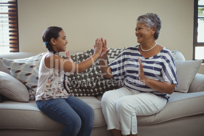 Grandmother and granddaughter having fun in living room