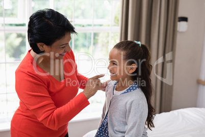 Cheerful grandmother and granddaughter at home