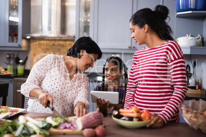 Happy multi-generation family preparing food at home