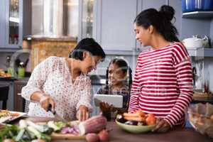 Happy multi-generation family preparing food at home