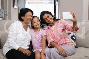 Happy multi-generation family taking selfie together at home