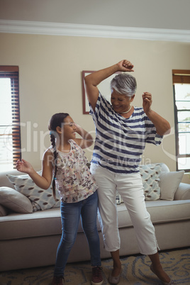 Grandmother and granddaughter having fun in living room