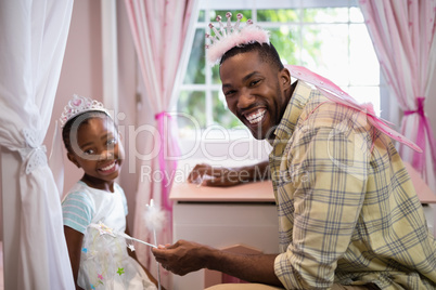 Happy father and daughter wearing costume wings at home