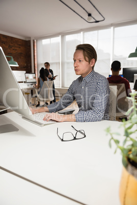 Male executive working on computer in office