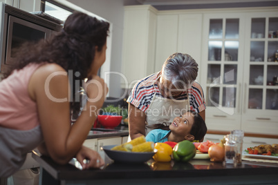 Smiling family interacting with each other in kitchen