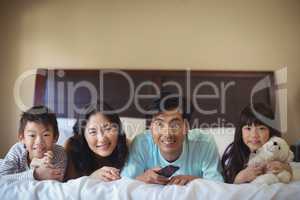 Happy family watching television in the bed room