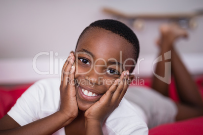 Portrait of happy boy lying on bed