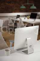 Computer and cup of tea on table