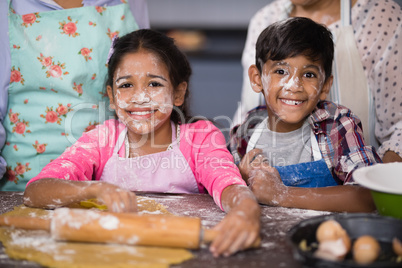 Portrait of smiling siblings with flour on face at home